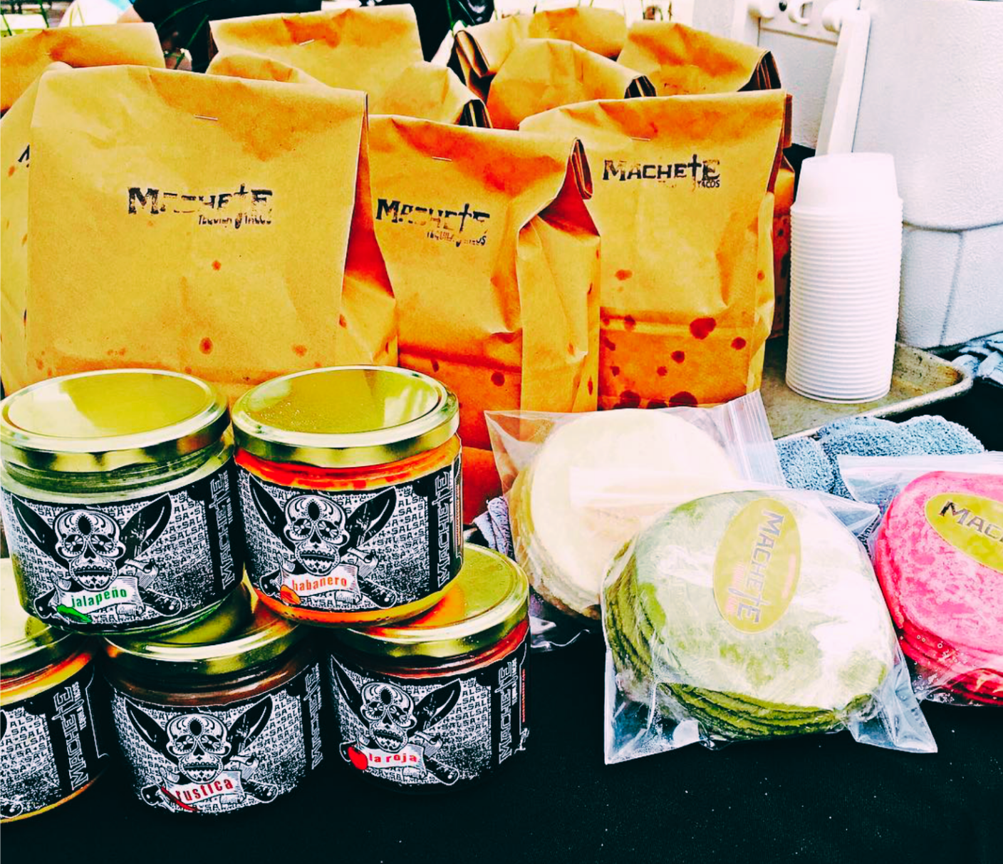 Taco ingredients: tortillas, sauces, and paper bags.
